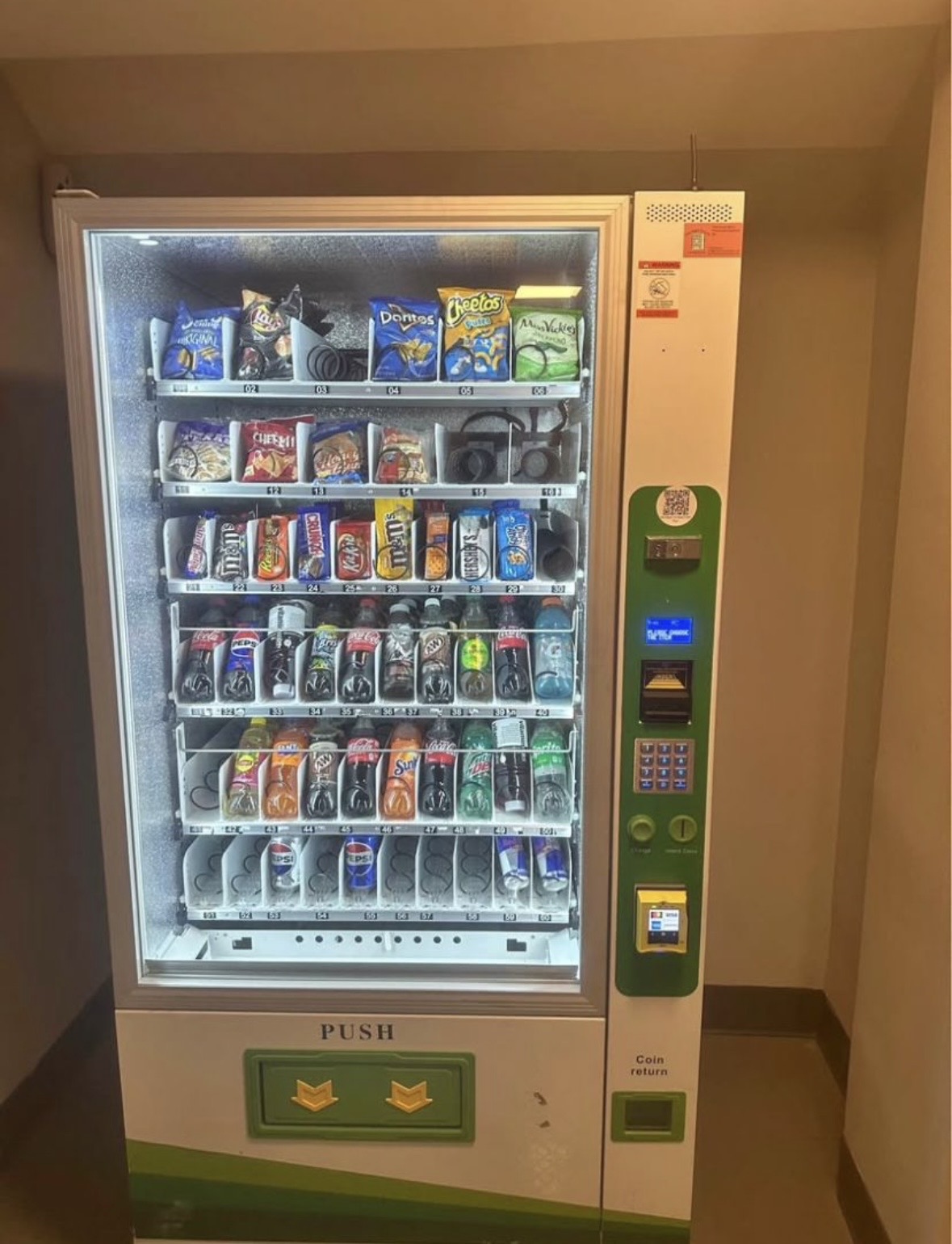 Full-size snack and drink combo vending machine installed in a hallway